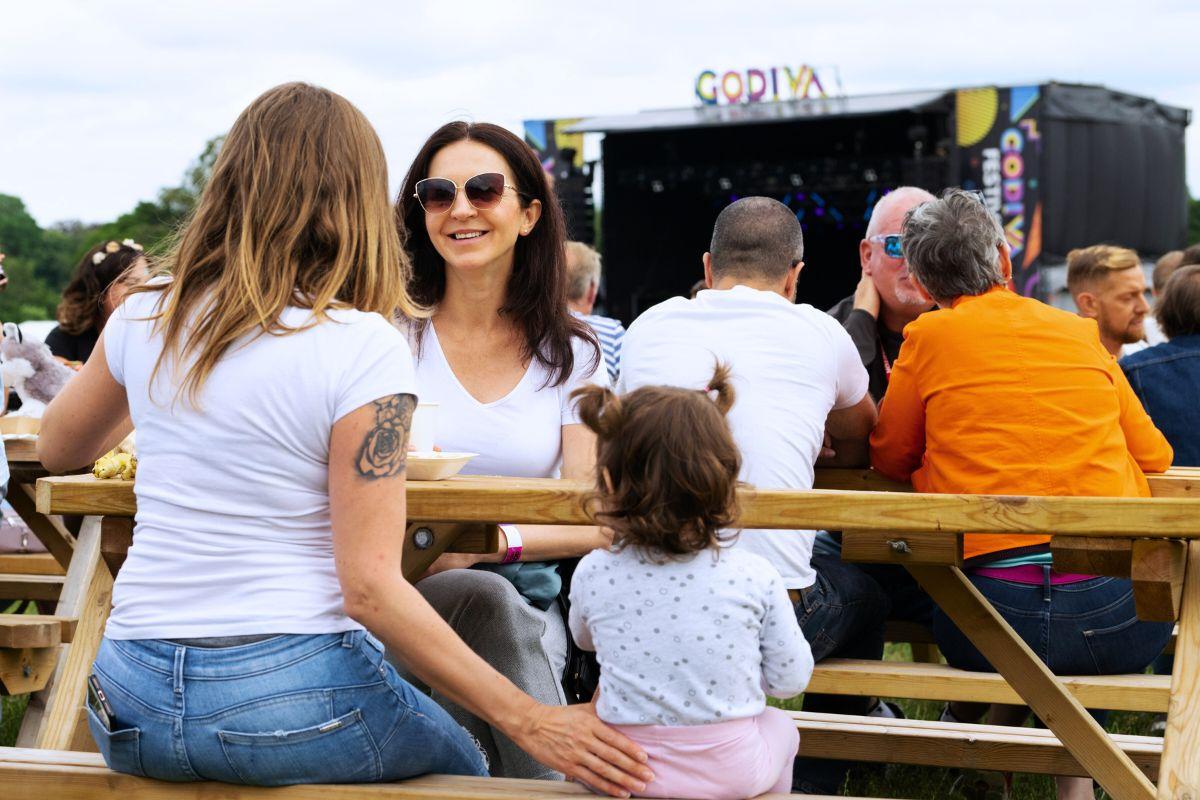 Family sat on benches at Godiva Festival