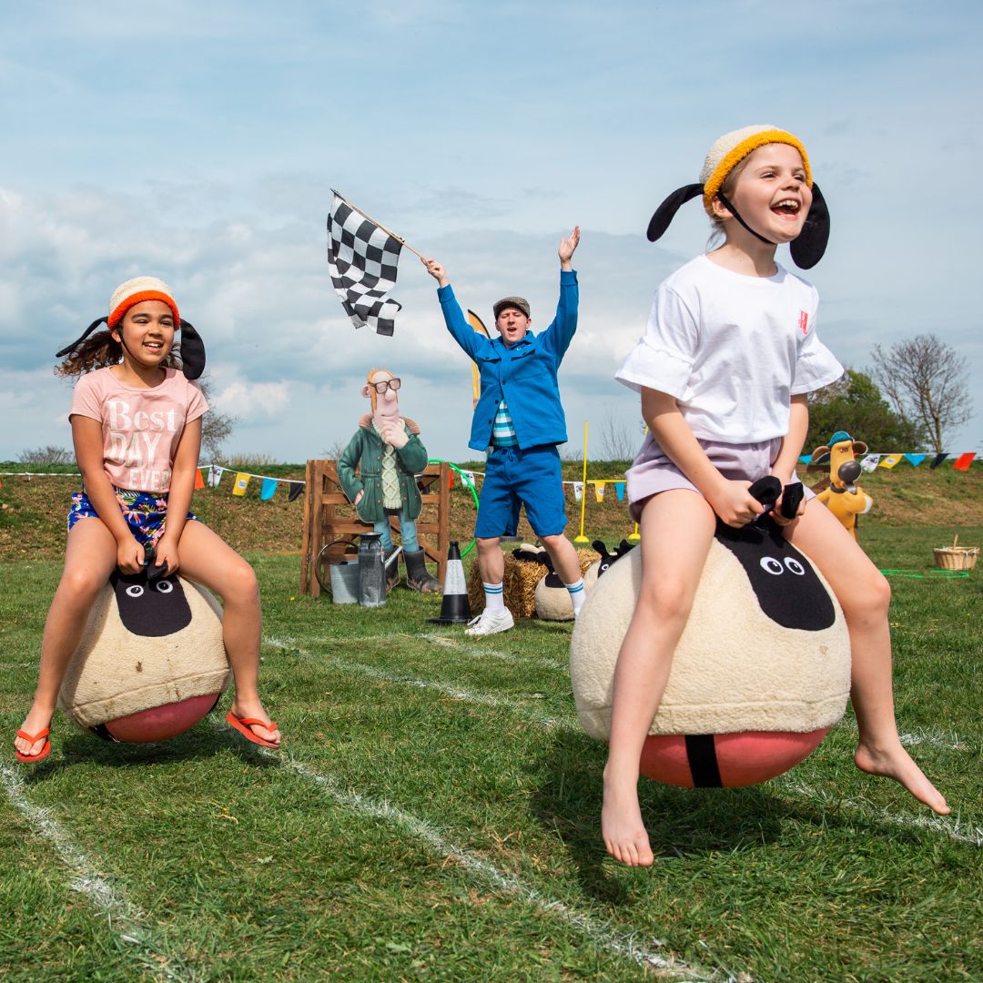 Two young girls playing on bouncy sheep