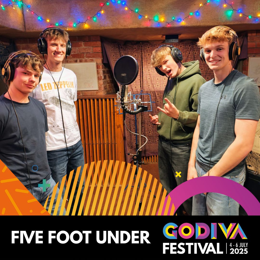 four people in a recording studio smiling at the camera