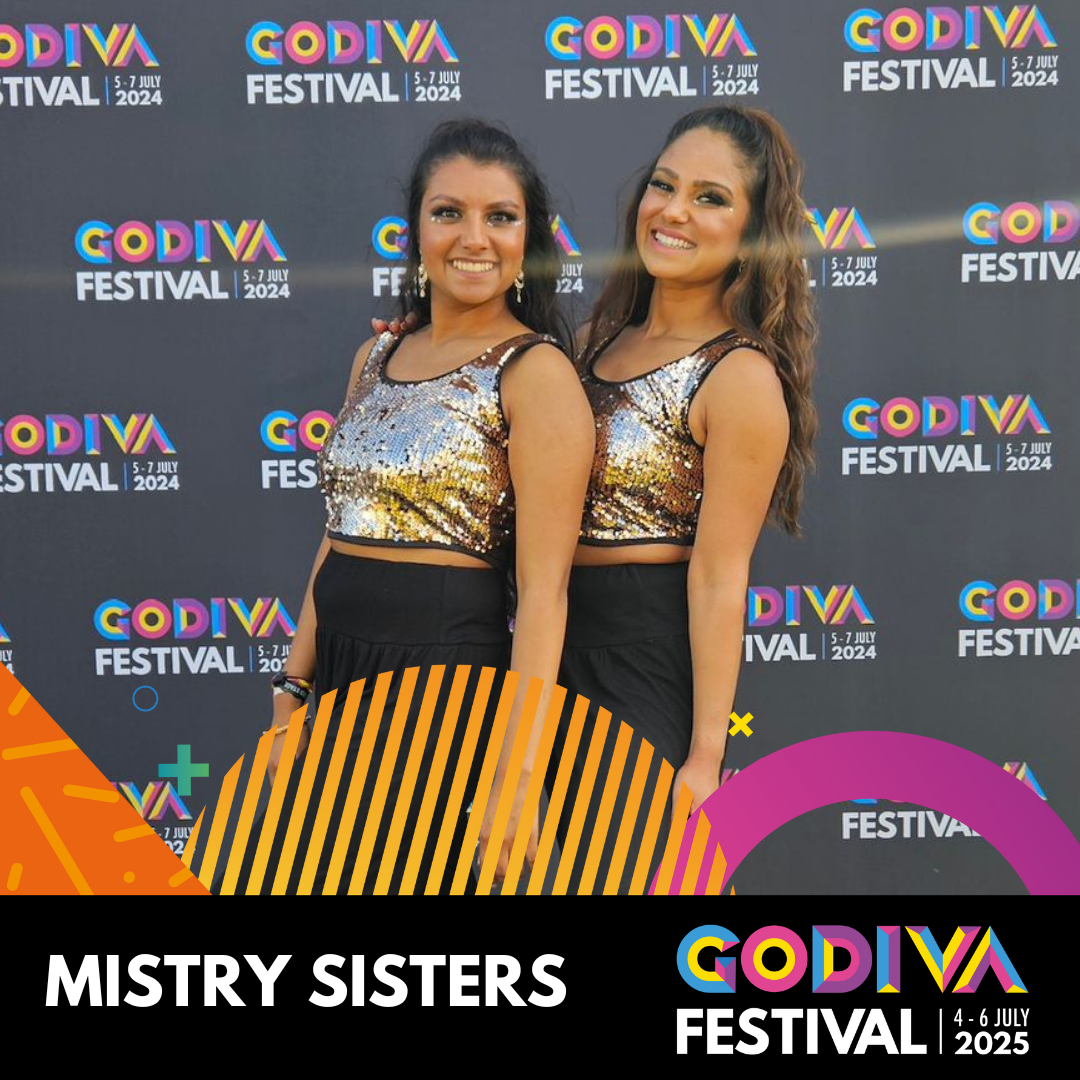 two girls in glitter tops with godiva festival background