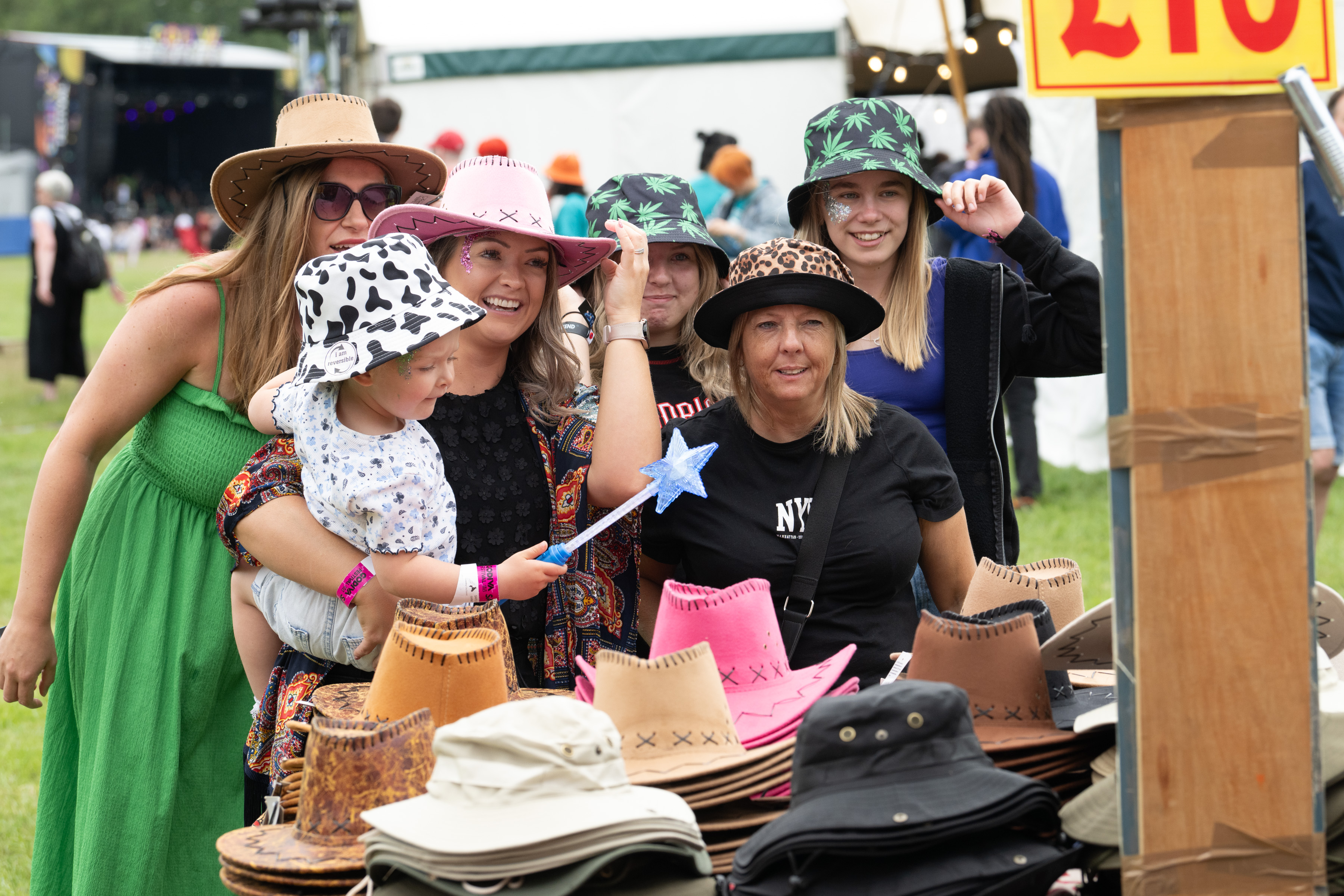 Group of people trying on hats at a stall