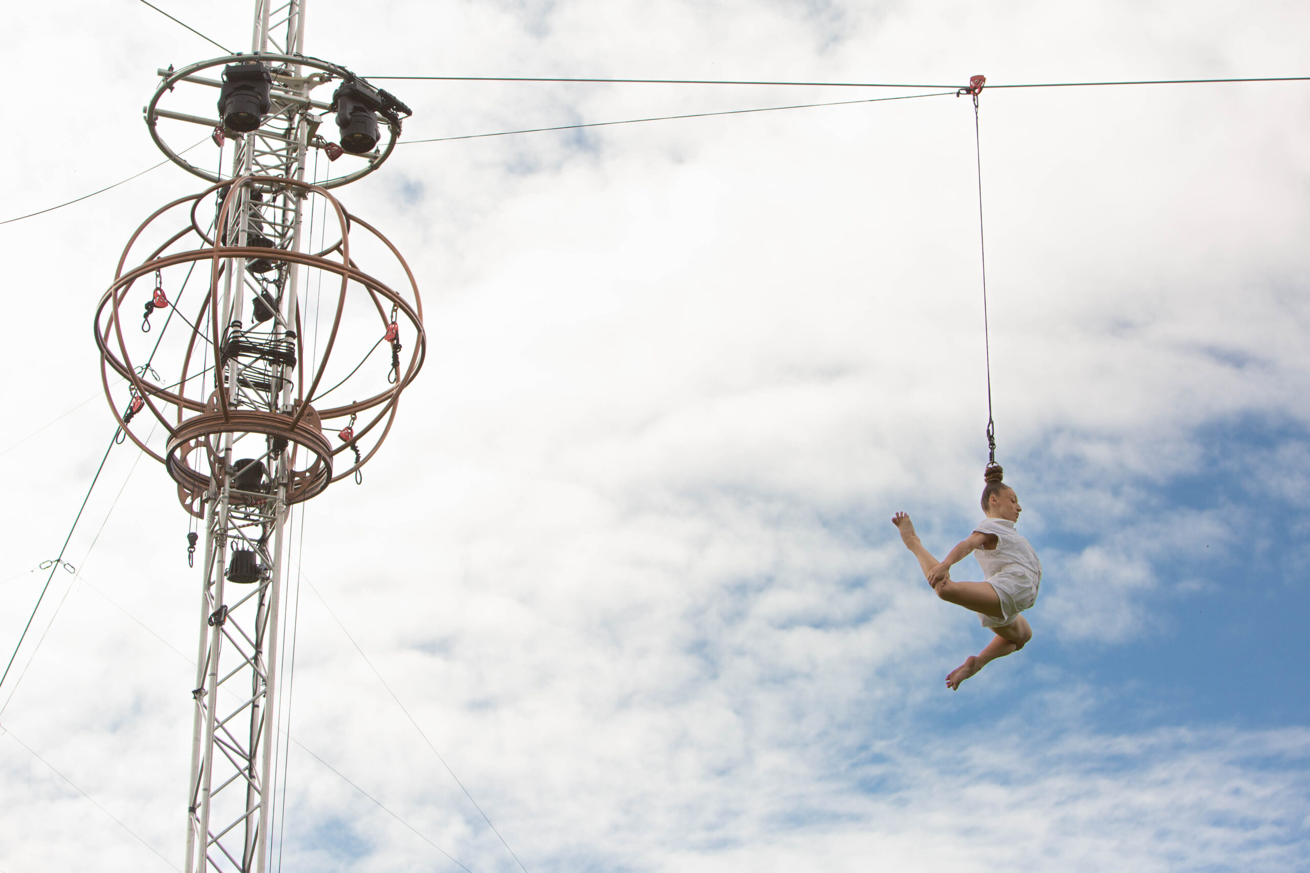 Photo of female acrobat suspended in the air by her hair