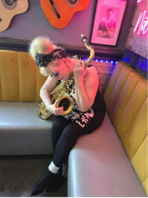 Woman sitting on a bench and embracing a saxophone