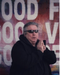 Man wearing sunglasses and clasping his hands together