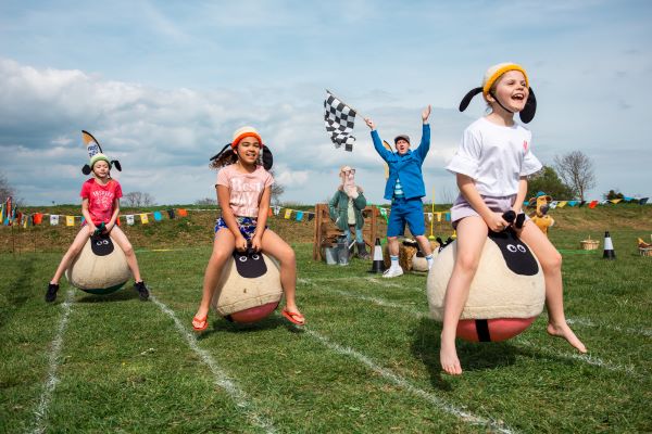 Three kids racing on space hoppers
